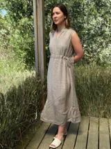 Vestido marrón de lino, corte midi, sin mangas, con cuello mao y cintura elastizada.