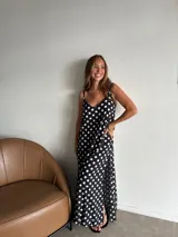 Vestido largo negro con estampado de lunares blancos, corte recto y tirantes finos.