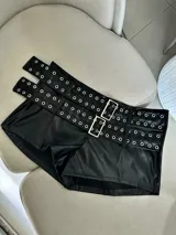 Micro short de cuero sintético color borgoña, con múltiples cinturones con hebillas metálicas y ojales.