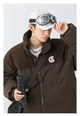 Campera puffer marrón con parte superior de pana y bordado blanco en la espalda con la palabra "Chingona". Tiene tiras regulables en la cintura.