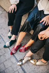 Botines bajos con estampado animal print en tonos verde y negro, con escote en V y borlas decorativas en el empeine.