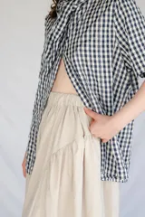 Falda midi color beige de microfibra con cintura elastizada y frunces laterales.