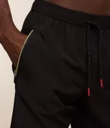 Bermuda deportiva negra sin estampado, con cintura elástica ajustable con cordón, y bolsillo lateral con cierre de cremallera contrastante.
