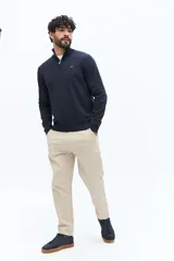 Sweater de tejido de punto color azul marino, con cuello medio y cierre parcial frontal. Presenta un pequeño logo bordado en el pecho.