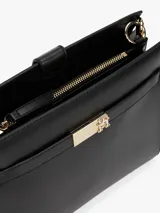 Cartera de hombro negra con correa fina ajustable y cierre dorado en la parte delantera.