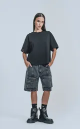 Bermuda de denim color negro con efecto acid wash y múltiples bolsillos cargo. Presenta un calce oversize y costuras marcadas.