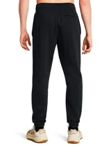 Pantalón de jogging Under Armour color negro, de corte holgado, con cintura elástica ajustable con cordón, bolsillos laterales y logo de la marca en la pierna izquierda.