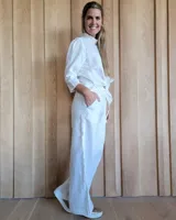 Pantalón de lino blanco con cintura elástica y bolsillos laterales, de corte amplio.