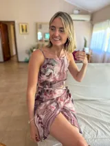 Conjunto de dos piezas compuesto por un top corto de tirantes finos y una minifalda cruzada con lazo, ambos con estampado abstracto en tonos malva, blanco y gris.