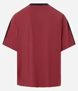 Remera deportiva masculina oversized color gris oscuro con cuello en V blanco, mangas cortas con rayas blancas, estampa localizada y lettering blanco.