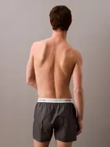 Bóxer suelto de hombre Calvin Klein, confeccionado en popelín de algodón con estampado de logos en gris y cintura elástica blanca con logo.