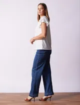 Blusa azul con cuello redondo, escote en V con aplique metálico y mangas cortas con volados en capas.