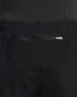 Short de running Nike Running Division, color negro, con short interior gris. Cuenta con tecnología Dri-FIT, tejido Ripstop repelente al agua, bolsillos laterales y trasero con cremallera, y bolsillo interior.