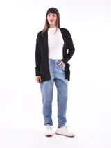 Saco color beige de tejido de punto, con cuello abierto, bolsillos frontales y mangas largas con detalle de botones en los puños.