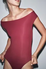 Body blanco de poliamida con cuello barco, manga corta y cierre con broches a presión en la entrepierna.