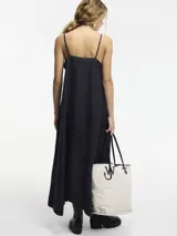 Vestido largo negro de lino con breteles finos regulables y escote en V. Presenta bordado monocromático en el frente.