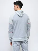 Campera con capucha Umbro de piqué, color gris con mangas negras y logo bordado en blanco.