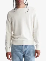 Sweater color crema de cuello redondo y corte clásico. Tiene un pequeño logo de la marca bordado en el pecho.