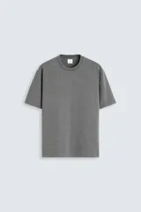 Camiseta gris de algodón, corte recto, cuello redondo y manga corta.