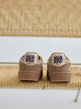 Championes urbanos de cuero color beige con pespuntes laterales en verde y azul. Suela de goma color caramelo.