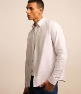 Camisa blanca de algodón, manga larga con botonadura frontal y cuello camisero.