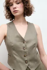 Chaleco sastre color amarillo mostaza, confeccionado en lino con forro de algodón y cierre frontal con botones.