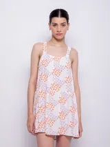 Vestido corto sin mangas con escote recto, con estampado de flores en tonos anaranjados y blancos.