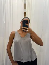 Musculosa gris de poliéster y rayón con spandex, escote en V y breteles anchos.