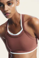 Top deportivo color ladrillo con escote redondo y tirantes blancos.