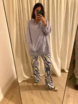 Combo de canguro con capucha color naranja y pantalón de jogging negro.