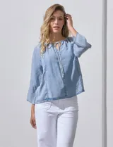 Blusa celeste de lyocell con cuello a la base y escote en V con lazo de ajuste. Manga larga amplia.