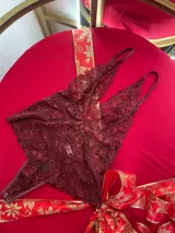 Body de encaje color bordó con breteles regulables y escote pronunciado.