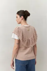 Chaleco color crema de tejido de punto, con cuello redondo y volados de crochet en el frente y la espalda.