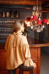 Blusa color beige de corte holgado, cuello alto con volados y mangas largas abullonadas con elástico en los puños.