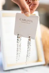 Aros largos plateados de acero quirúrgico con diseño de cadenas de pequeñas placas metálicas.