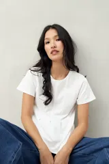 Remera blanca de algodón con cuello redondo y costuras verticales en el frente.