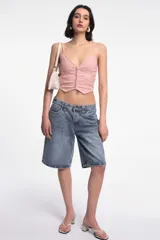 Top negro con breteles finos, escote en V y abotonadura frontal.