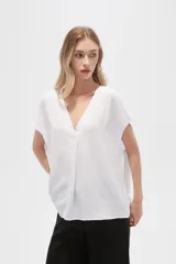 Blusa blanca de poliéster, lisa, holgada y con cuello en V.
