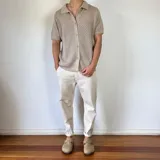 Camisa negra tejida con diseño calado, manga corta y corte regular.