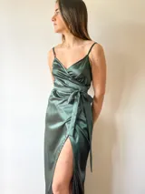 Vestido largo color fucsia de satén, con escote cruzado, breteles finos y lazo en la cintura.