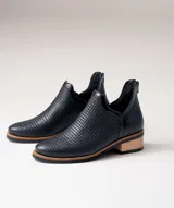 Botín de cuero negro con textura de rejilla y tacón bajo.