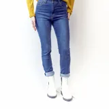 Bota Chelsea blanca de cuero sintético con elástico lateral negro adornado con tachas plateadas. Tiene suela track negra y taco bajo.