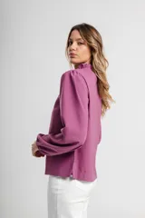 Blusa de manga larga color mostaza con escote redondo y detalle de fruncido en el cuello.