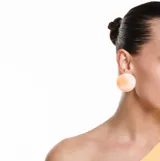 Aros de diseño moderno y minimalista en color naranja, con forma esférica y referencias a los años 80.