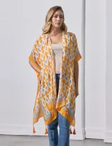 Kimono tejido color naranja con estampado geométrico en blanco y celeste, y terminación con borlas.