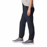 Pantalón de trekking color azul marino, confeccionado con 50% de nailon reciclado, repelente al agua y a las manchas. Cuenta con cintura cómoda plisada, múltiples bolsillos (manos, seguridad con cremallera, cargo, trasero de seguridad) y pernera cónica con bajo parcialmente elástico.