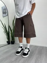 Bermuda marrón chocolate de corte ancho, largo a la rodilla, con bolsillos cargo y costuras a contraste en color blanco.
