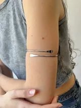 Brazalete de acero plateado con diseño moderno y minimalista, ideal para completar cualquier look.