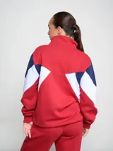 Campera deportiva Umbro, roja con detalles en blanco y azul. Cierre frontal con cremallera, cuello alto y logo del Club Nacional de Football bordado en el pecho.