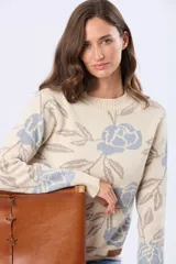 Buzo tejido en jacquard color crema con estampado de rosas azules y hojas marrones. Tiene cuello redondo y puños de rib.